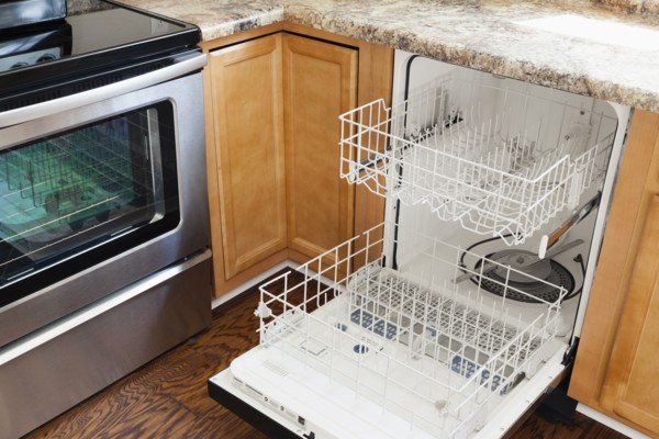 Empty open dishwasher in domestic kitchen