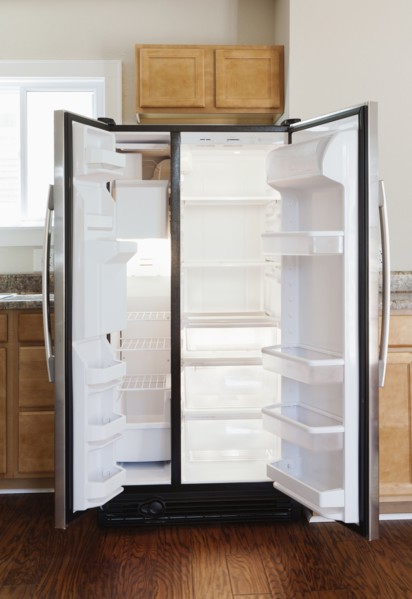 Empty open fridge in domestic kitchen