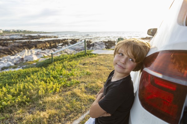 Portrait of Boy leaning on SUV