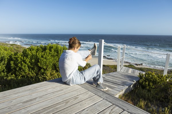 Girl sitting on boardwalk