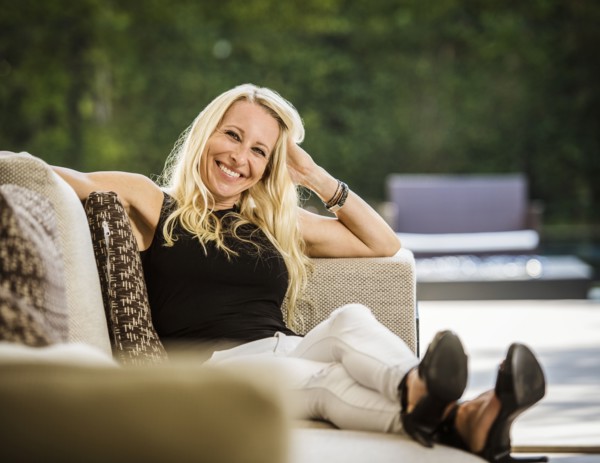 Portrait of smiling blond woman sitting on sofa