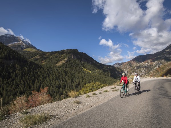 Man and woman riding bicycles on mountain road