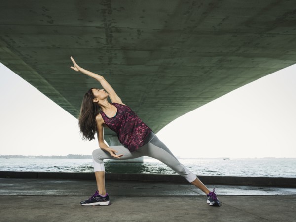 Woman stretching under bridge