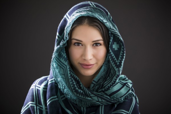 Studio portrait of smiling woman with shawl on head