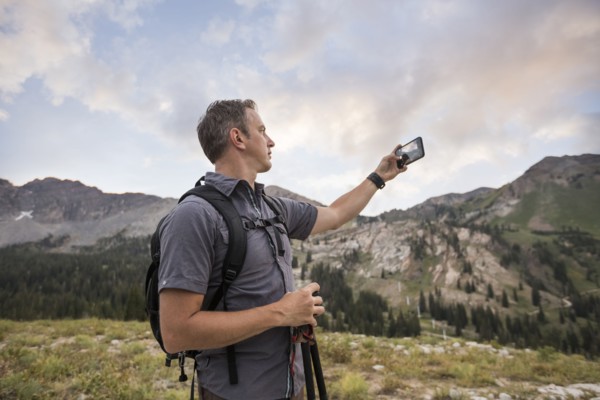 Male hiker photographing mountain landscape