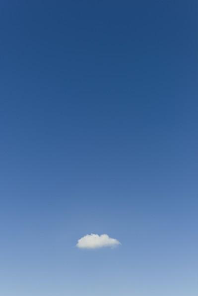 Blue sky with single small cloud