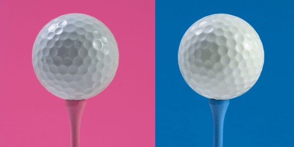 Golf balls on tee against pink and blue background