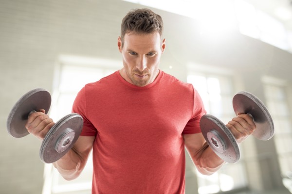 Man exercising with dumbbells in gym