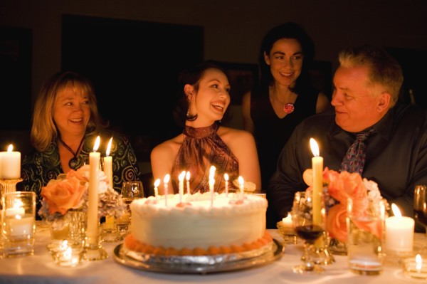 Group of friends celebrating birthday in restaurant