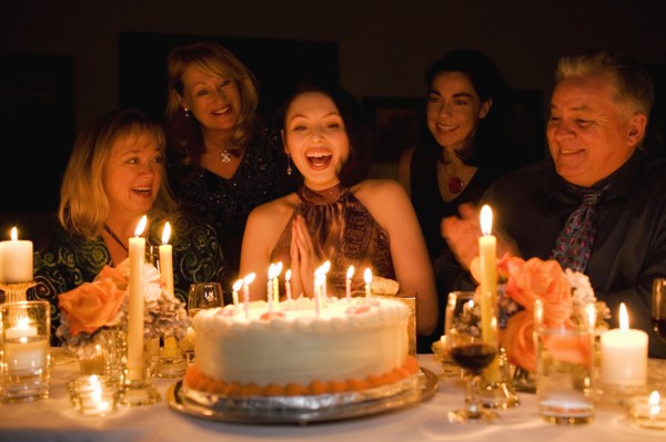 Group of friends celebrating birthday in restaurant