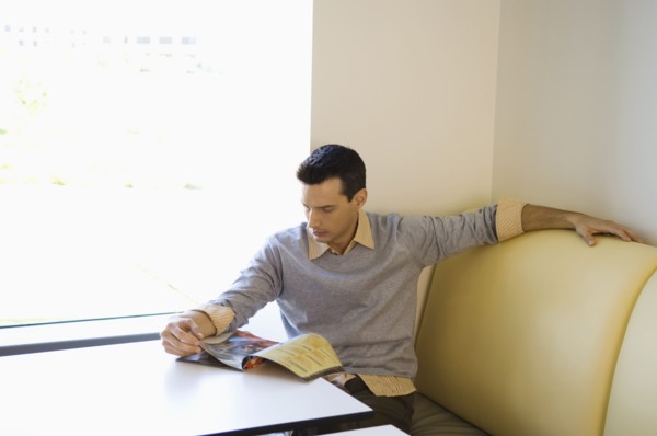 Businessman reading magazine in cafeteria