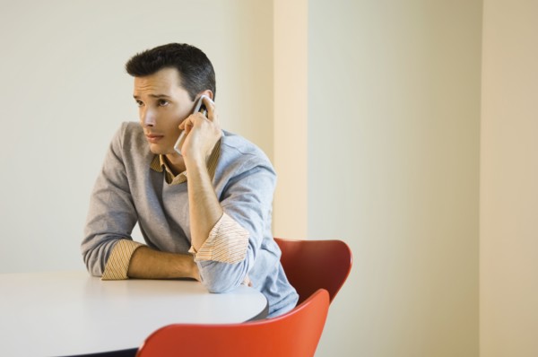 Man sitting at table using mobile phone