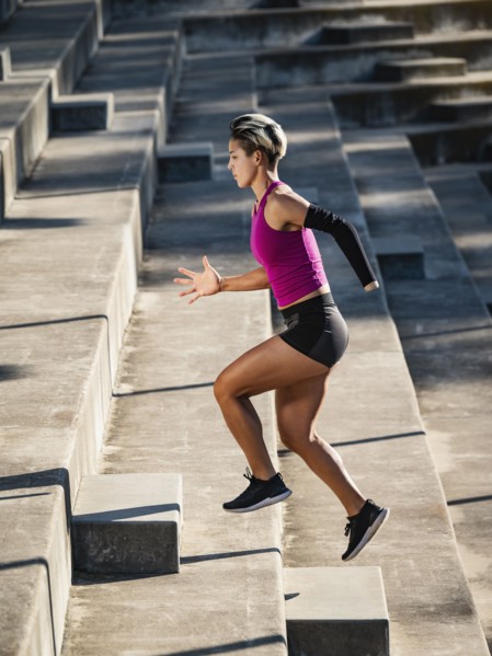 Athletic woman with amputated hand running up steps