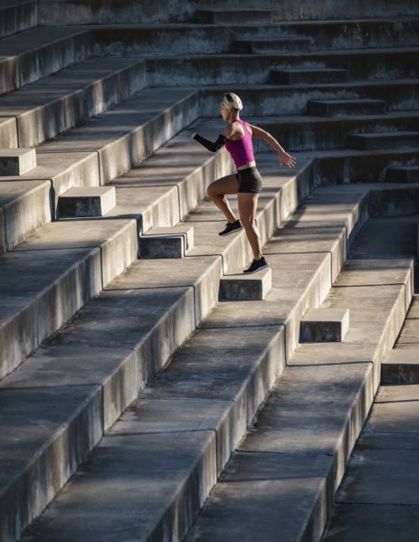 Athletic woman with amputated hand running up steps