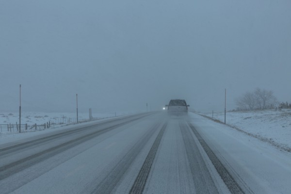 Pick-up truck on snow covered highway 20 in rural landscape