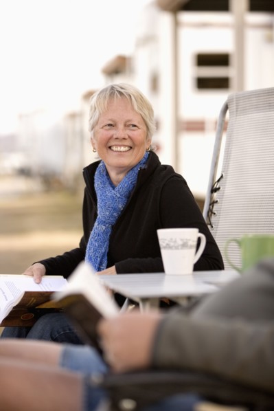 Senior couple reading book outside mobile home