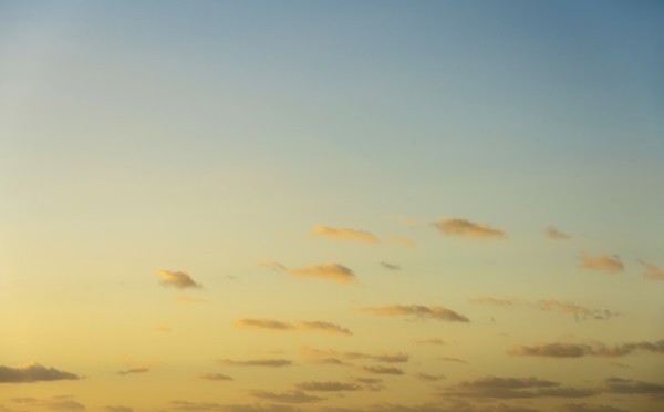 Blue sky with small calm clouds at sunrise