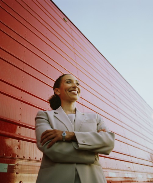 Businesswoman standing next to cargo container