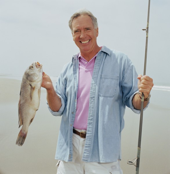 Portrait of smiling fisherman holding catch