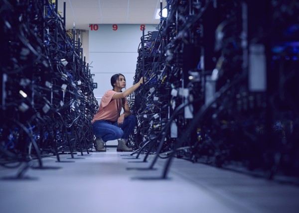 Female technician working in server room