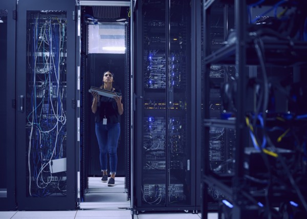 Female technician carrying hard drive in server room