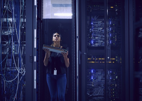 Female technician carrying hard drive in server room