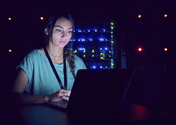Technician using laptop in server room
