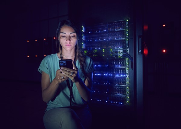 Technician using smart phone in server room