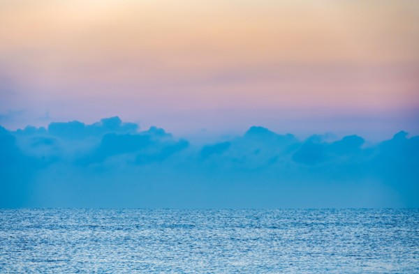 Clouds above calm ocean at sunrise