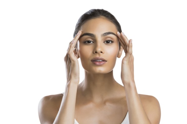 Portrait of serious young woman doing face massage