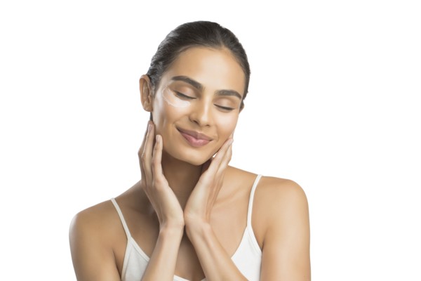 Portrait of smiling young woman applying face cream