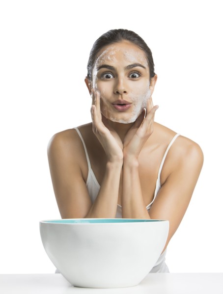 Portrait of young woman enjoying washing face