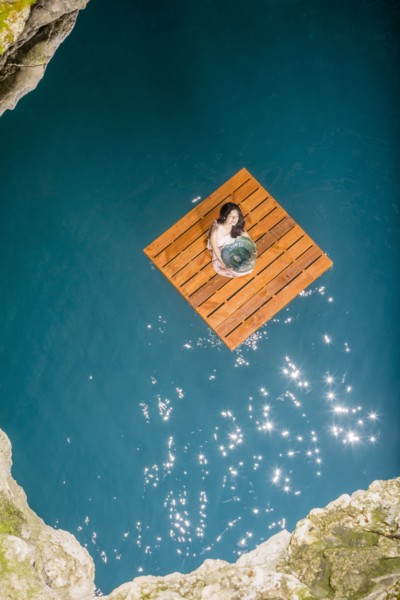 Aerial view of woman sitting on wooden raft