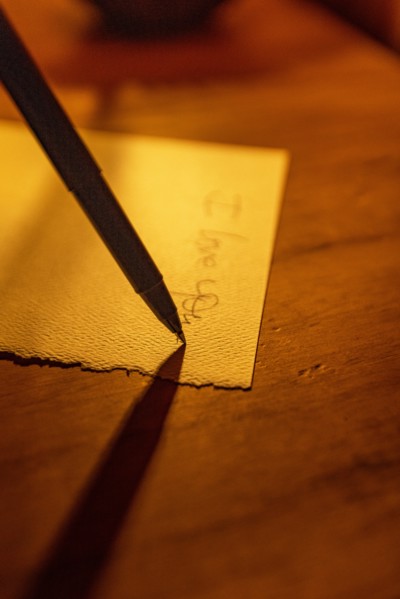 Close-up of pen writing on linen notecard