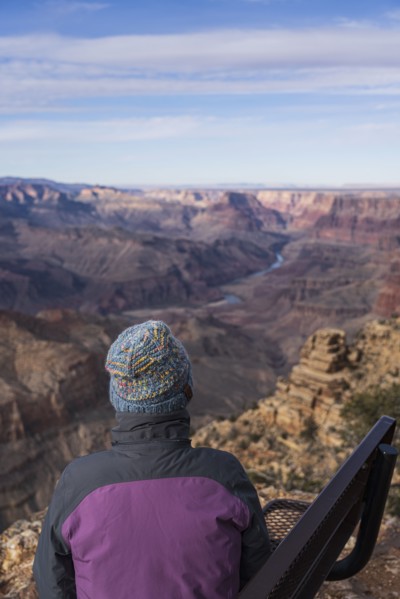 Rear view of female tourist sitting on bench in Grand Canyon National Park