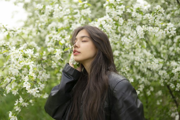 Portrait of teenage girl with blooming apple tree