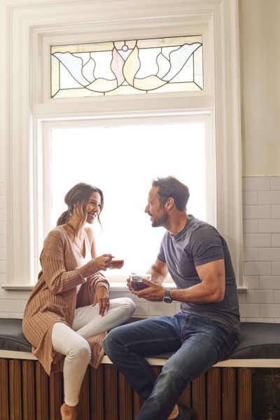 Smiling couple relaxing by window at home