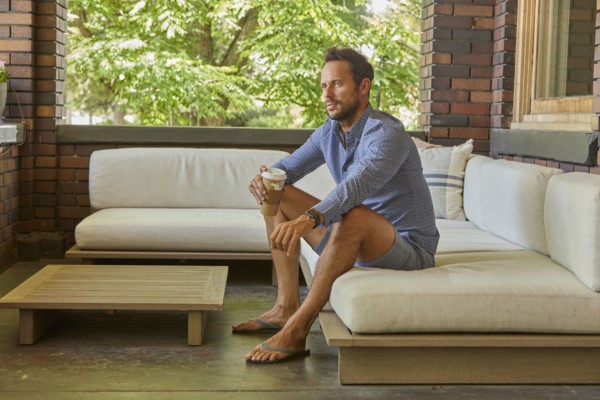 Mid adult man relaxing on sofa on patio