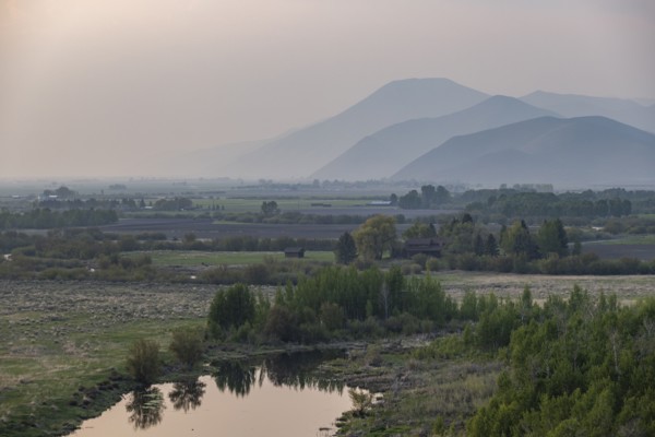 Landscape with small pond and mountains in background