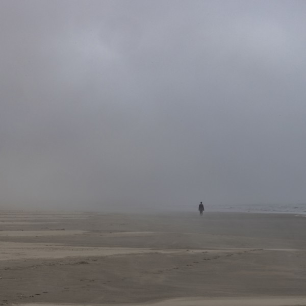 Misty figure walks along beach