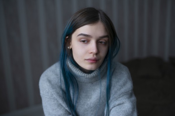 Portrait of serious woman in gray sweater