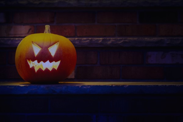 Illuminated Halloween jack-o-lantern on porch at night, Chatham, New Jersey, USA