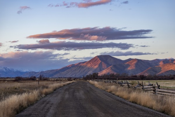 Empty dirt road leading to foothills at sunset, Bellevue, Idaho, USA