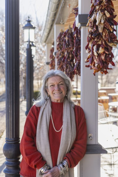 Portrait of smiling woman leaning against column at sidewalk cafe, Lamy, New Mexico, USA