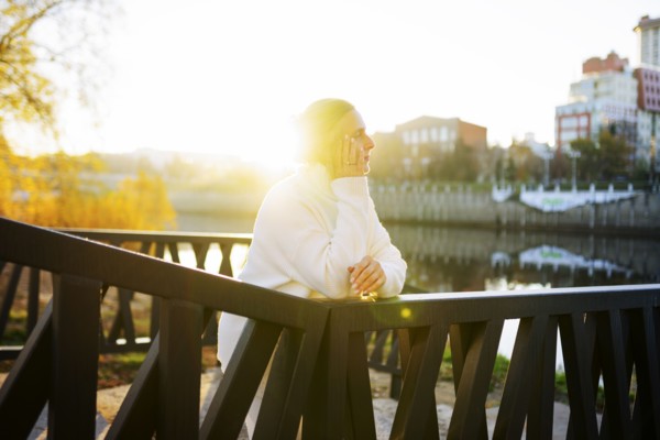 Woman in white sweater leaning on bridge, Omsk, , Russia