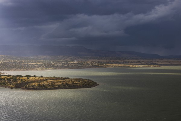 Usa, New Mexico, Abiquiu, Sun shining through storm clouds over Abiquiu Lake, Abiquiu, New Mexico,