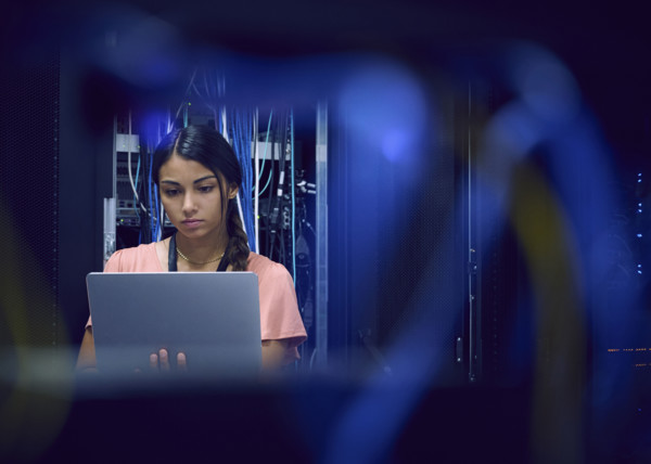 Female technician using laptop in server room 
St, George, Utah, USA