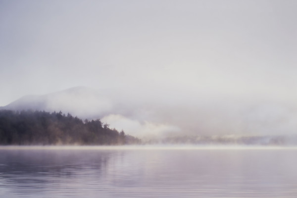 Morning mist rising over calm Lake Placid 
St. Armand, New York, USA