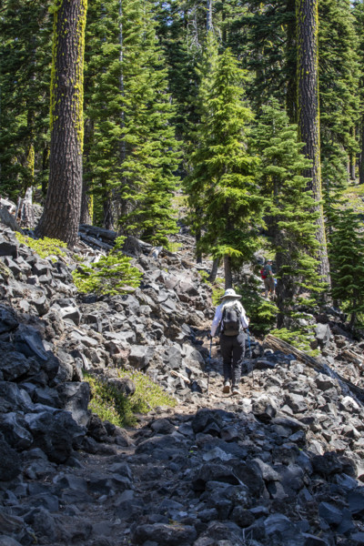 USA, Oregon, Crater Lake, Rear view of female hiker on rocky trail