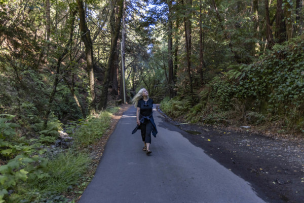 USA, California, Mill Valley, Woman walking on paved pathway in forest